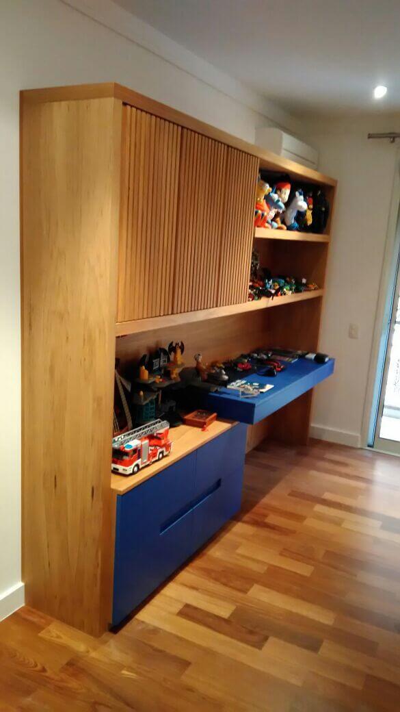 Decoração de quarto de menino com escrivaninha e estante para guardar brinquedos