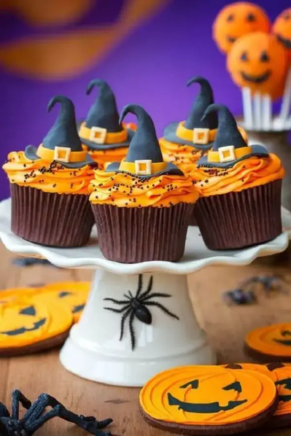 decoração de mesa dia das bruxas com aranhas de brinquedo e cupcake personalizado Foto Musely