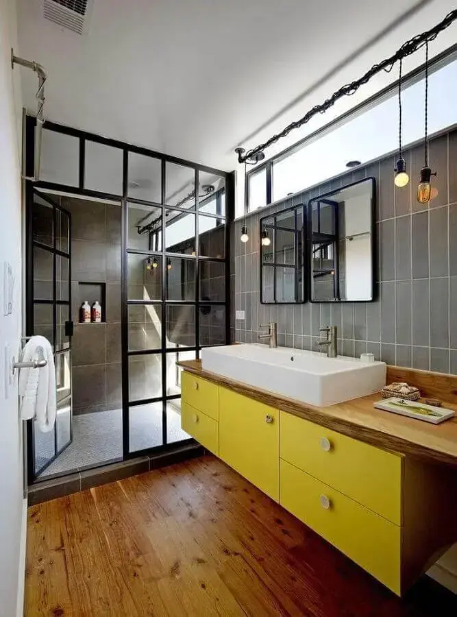 decoração estilo industrial para banheiro com bancada de madeira e armário amarelo Foto Robert Nebolon Architects