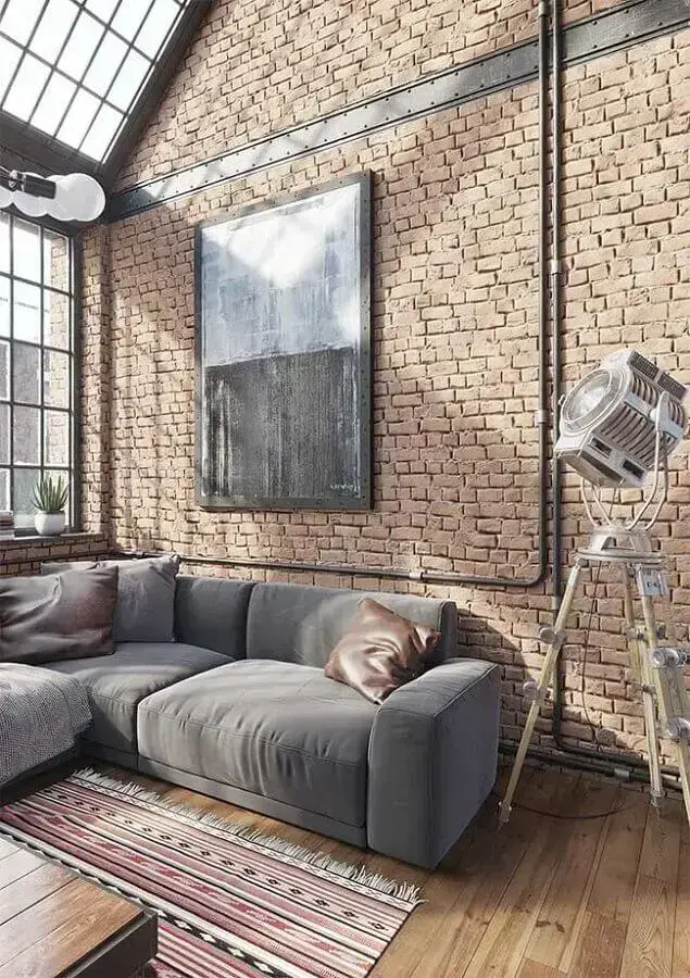 decoração industrial sala de estar com sofá cinza e parede de tijolinho Foto Arquiteto Versátil