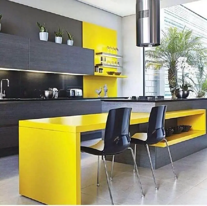 decoração moderna para cozinha planejada amarela e preta com iluminação embutida em armário aéreo e ilha com coifa Foto Design by Colors