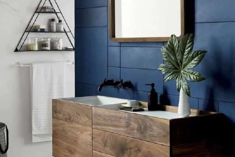 decoração para banheiro moderno com parede azul marinho e gabinete de madeira