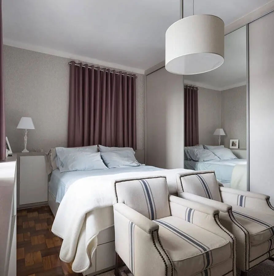 decoração simples para quarto de casal com poltronas e guarda roupa branco com espelho Foto Kali Arquitetura