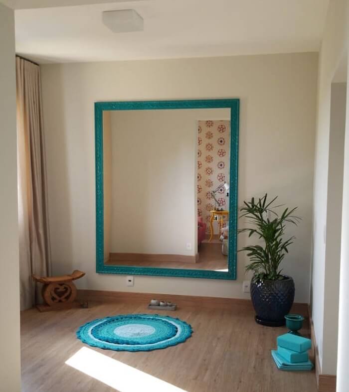 Moldura para espelho grande no tom azul turquesa combina com o tapete do ambiente
