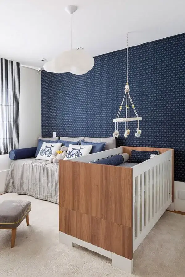 papel de parede azul marinho para decoração de quarto de bebê com berço de madeira Foto Webcomunica