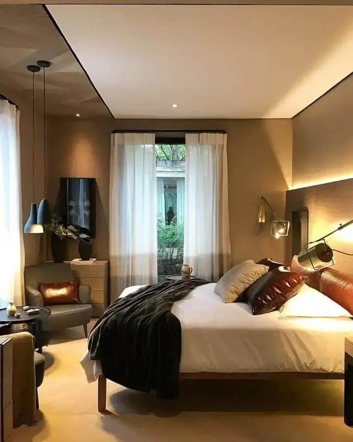 poltrona para quarto de casal com luminária moderna e cabeceira de couro Foto Prado Zogbi Tobar Arquitetura