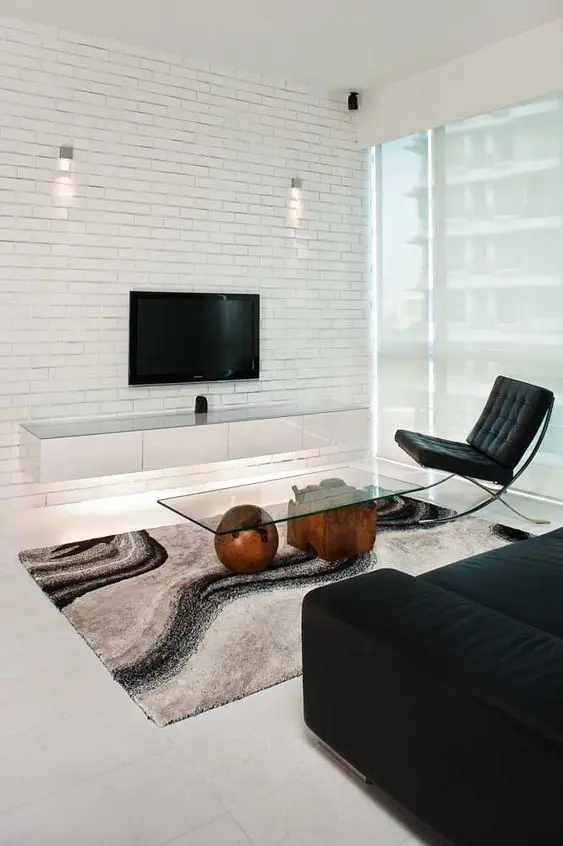 sala de estar com rack suspenso branco em parede de tijolos 