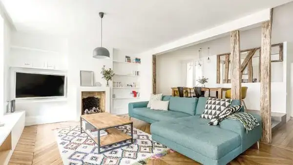 Sala clean com sofá colorido azul claro e almofadas modernas