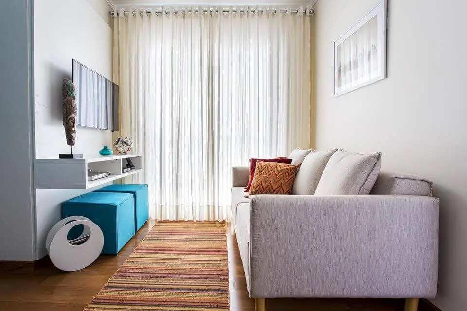 sofá para apartamento - sala pequena com puffs turquesa 