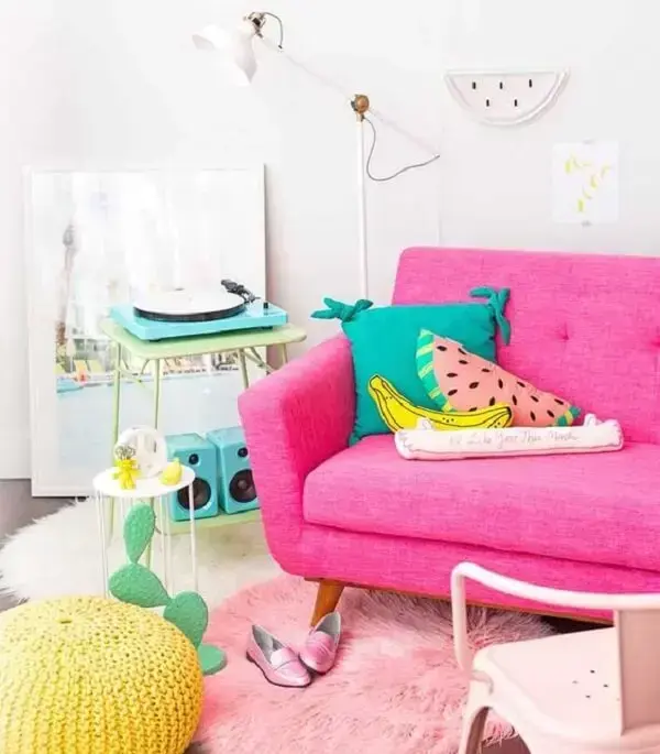 Almofadas divertidas complementam a decoração da sala de estar com sofá rosa