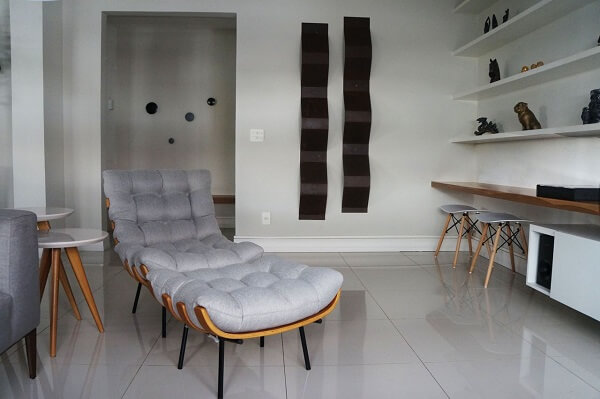 Ambiente decorado com mesa lateral de laca e poltrona cinza claro