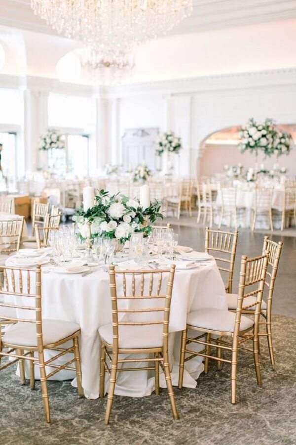 As cadeiras douradas trazem um toque sofisticado para a decoração de bodas de ouro