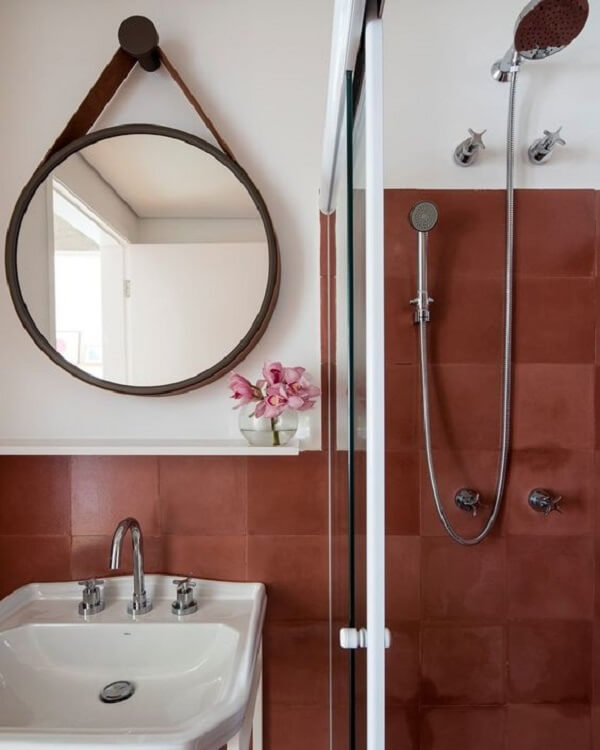 Azulejo terracota e espelho adnet decoram o banheiro. Fonte: Casa Vogue