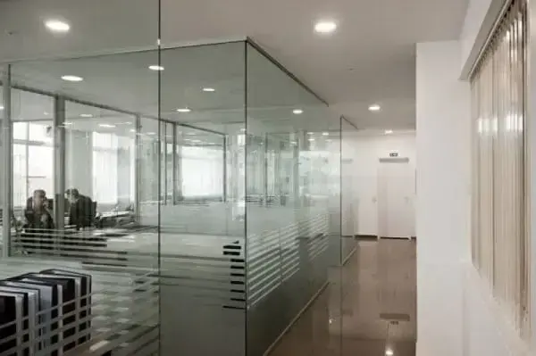 Escritório com salas de reunião separadas por portas de vidro jateado