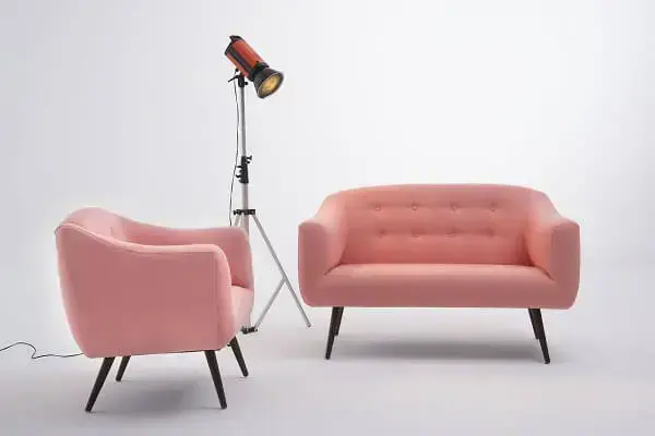 Sofá rosa e poltrona decoram o ambiente