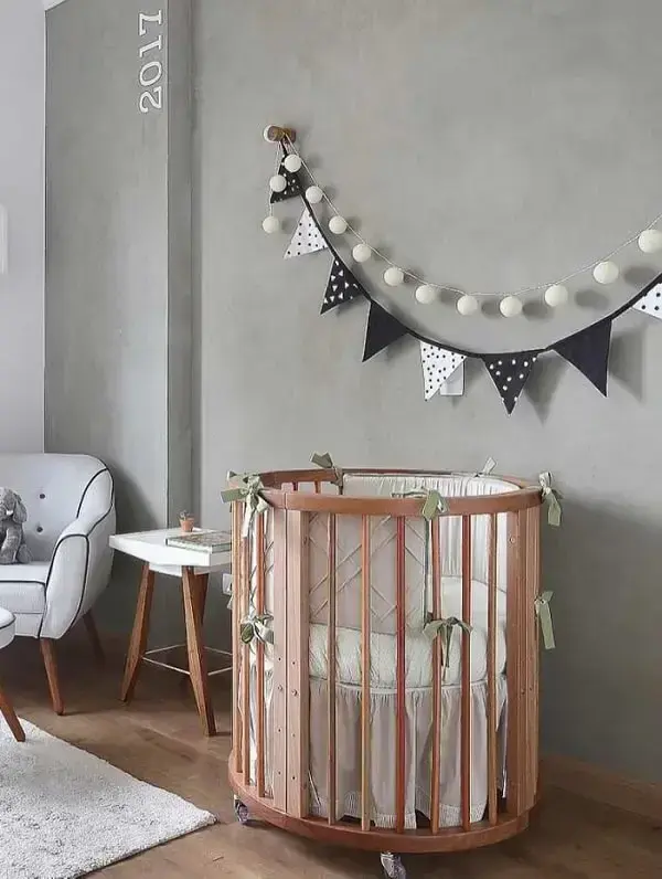 O quarto de bebê pode receber um acabamento especial com parede de cimento queimado