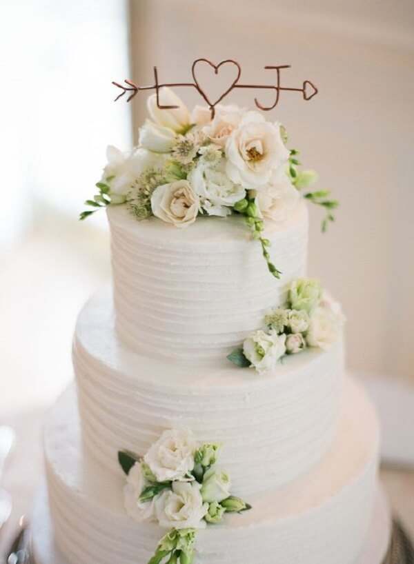 O topo do bolo de casamento pode receber as iniciais dos noivos. Fonte: Tourterelle Floral Design