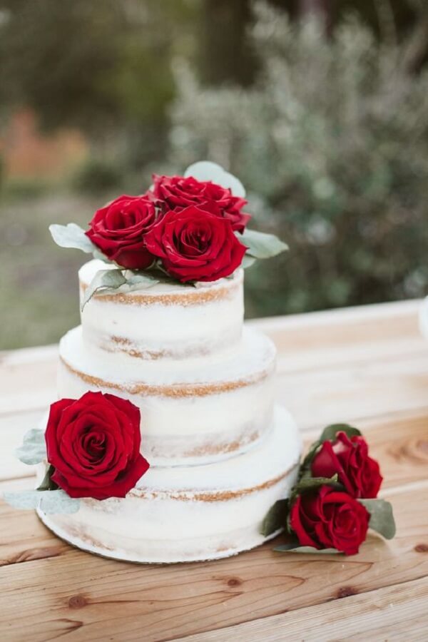 Rosas vermelhas destacam as camadas do bolo de casamento. Fonte: La Petite Photo