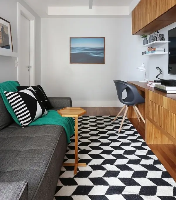 Sala compacta com sofá cinza e tapete geométrico preto e branco
