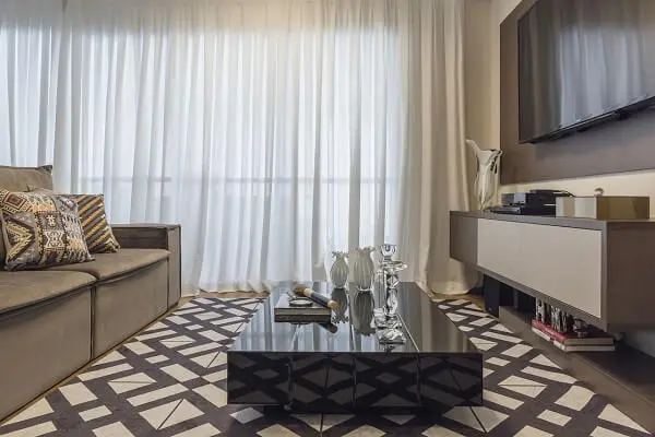 Sala de Tv com cortinas brancas e tapete geométrico