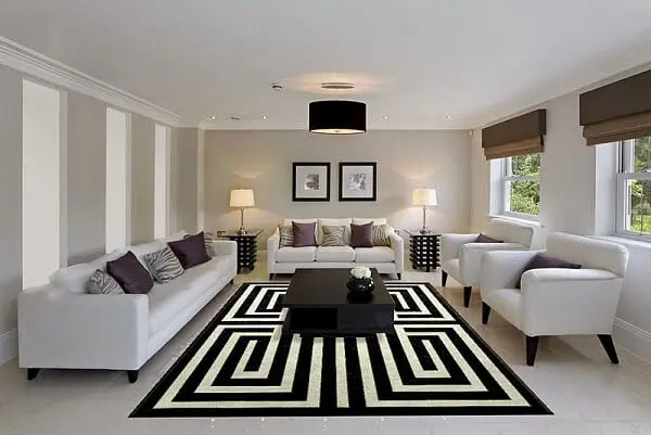 Sala de estar ampla com móveis claros e tapete geométrico preto e branco