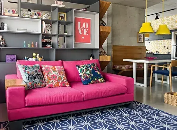 Sala de estar com sofá rosa pink e almofadas estampadas