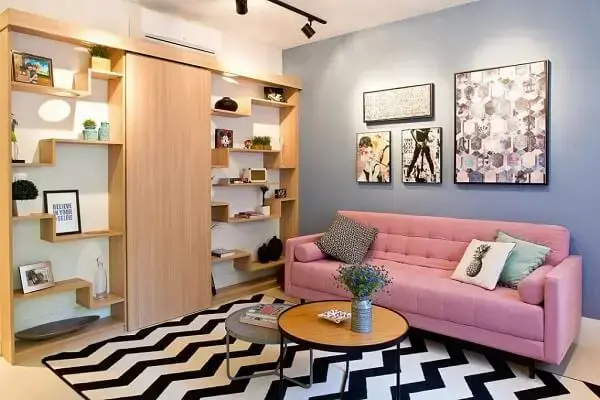 Sala de estar com tapete chevron e sofá rosa claro