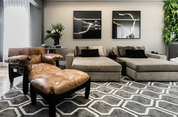Sala de estar com tapete geométrico cinza e poltrona de couro. Fonte: Pinterest