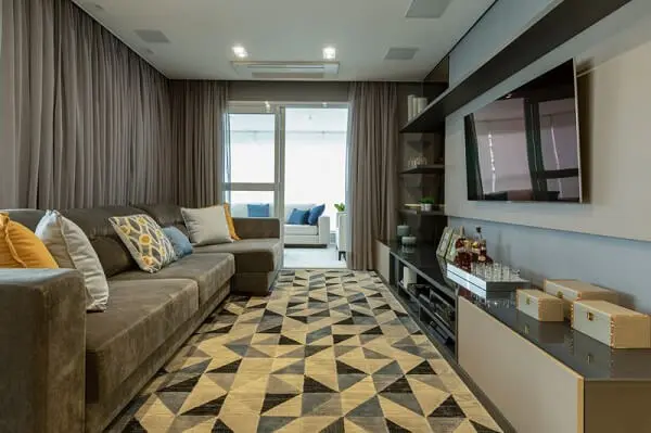 Sala de estar compacta com sofá cinza e tapete geométrico mesclado