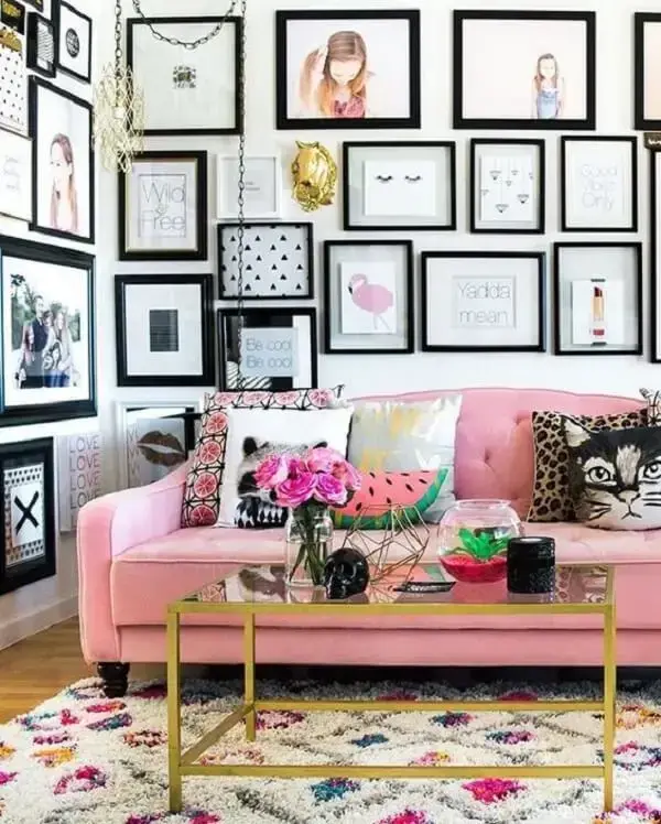 Sala de estar repleta de quadros decorativos e sofá rosa