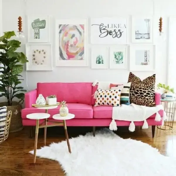 Sofá rosa com manta branca e tapete felpudo