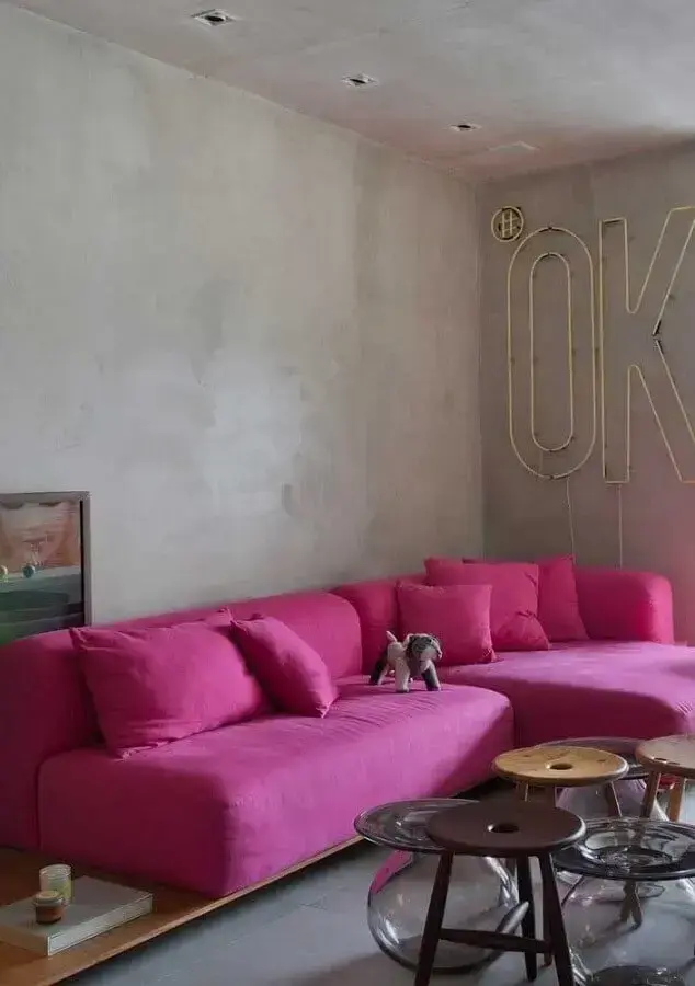 Sofá rosa pink de canto para sala estilo industrial decorada com parede de cimento queimado Foto Futurist Architecture