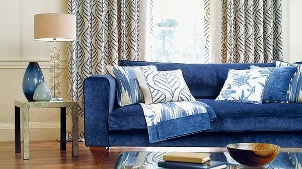 Sofá suede em tom azul e almofadas estampadas
