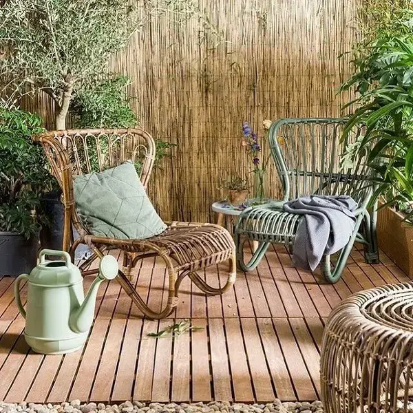 Terraço aconchegante com cerca de bambu e cadeira de madeira