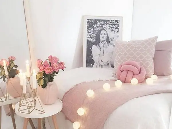 A almofada de nó rosa combina com os demais objetos do quarto