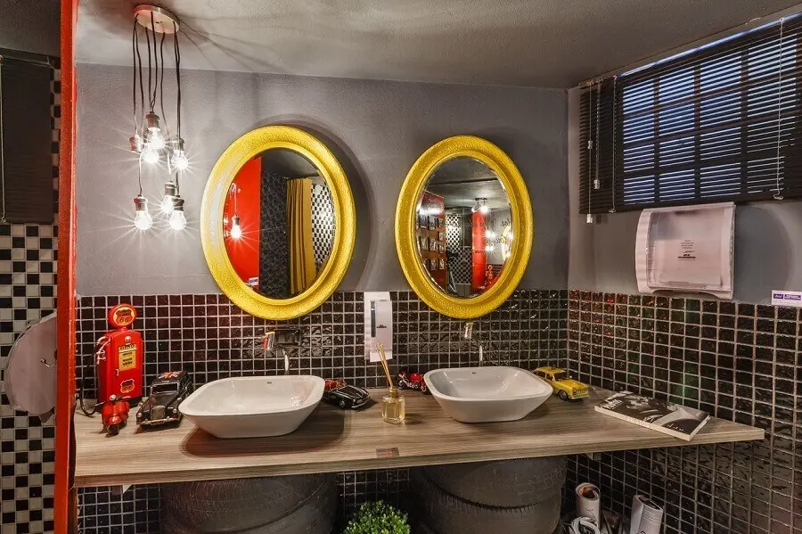 banheiro cinza decorado com bancada de madeira e espelho com moldura amarela Foto Lídici Melo
