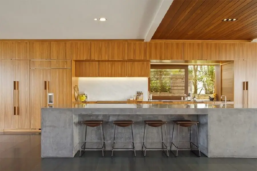 cozinha ampla com bancada de concreto e armários de madeira Foto Limaonagua
