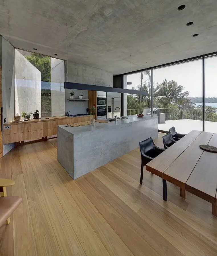 cozinha ampla decorada com bancada de concreto e armários de madeira Foto Bella Vie Interiors