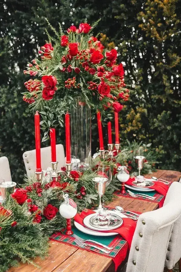 decoração de mesa natalina com velas e arranjo de flores vermelhas Foto Style Me Pretty