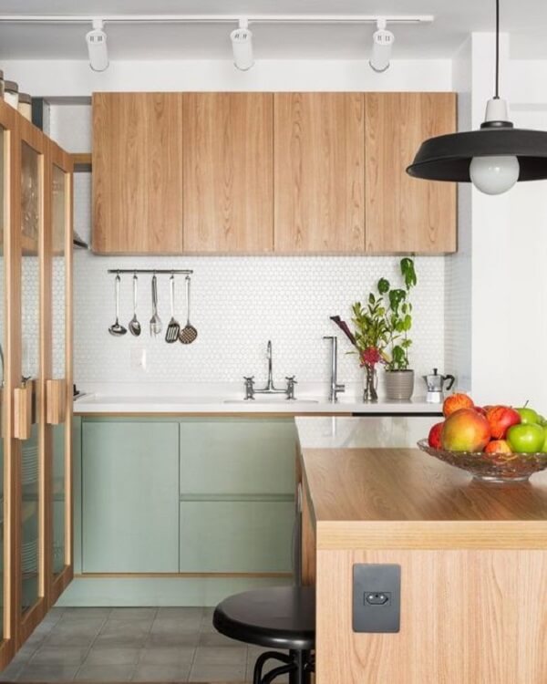 Cozinha com armário e bancada de madeira e Spot de trilho em tom branco