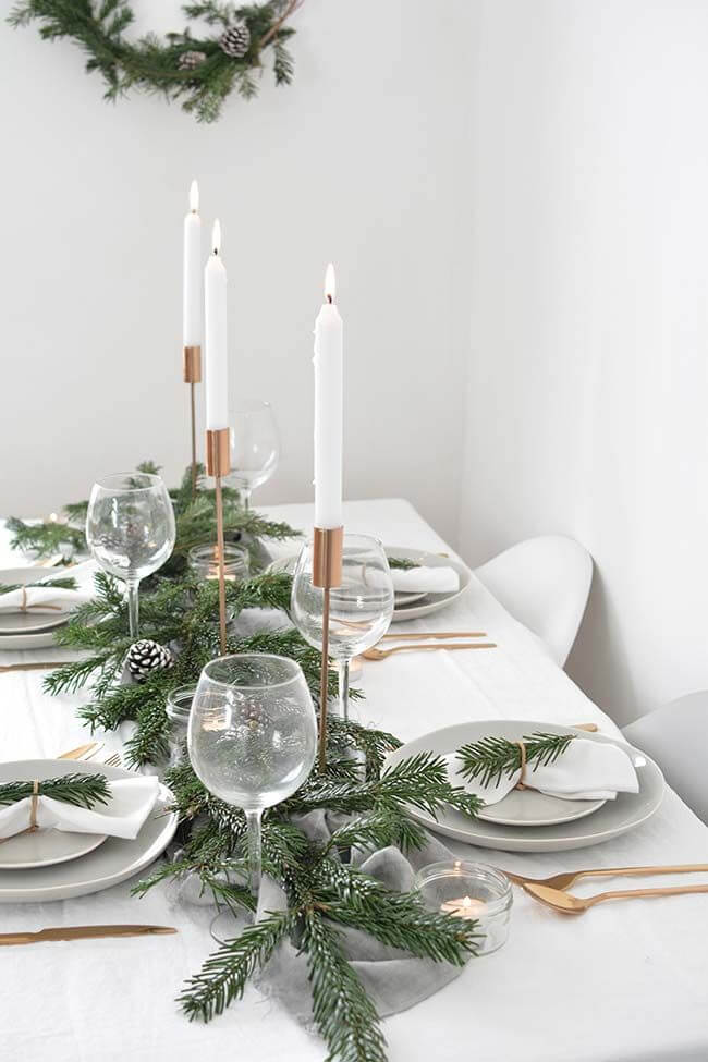 Decoração mesa de natal simples com plantas e velas altas