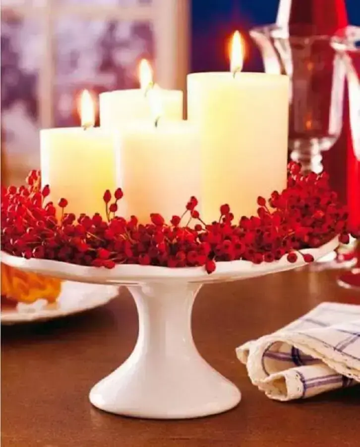 decoração natalina simples com arranjo de velas e planta vermelha Foto Vera Moraes
