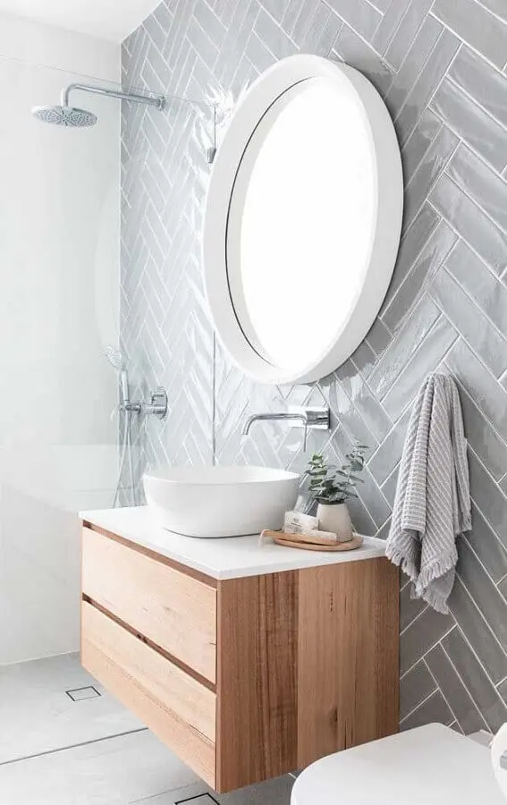 decoração para banheiro cinza e branco com espelho redondo e armário de madeira pequeno Foto Pinterest