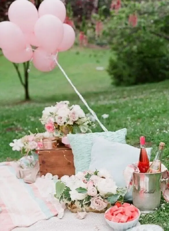 piquenique romântico decorado com arranjo de flores e balões cor de rosa Foto Dreamery Events