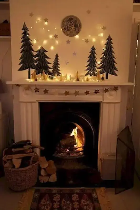 sala com lareira com decoração de Natal simples com estrelas douradas e pequenos pinheiros Foto Pinterest