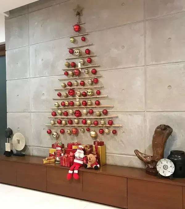 Árvore de Natal de parede feita com galhos e bolinhas coloridas