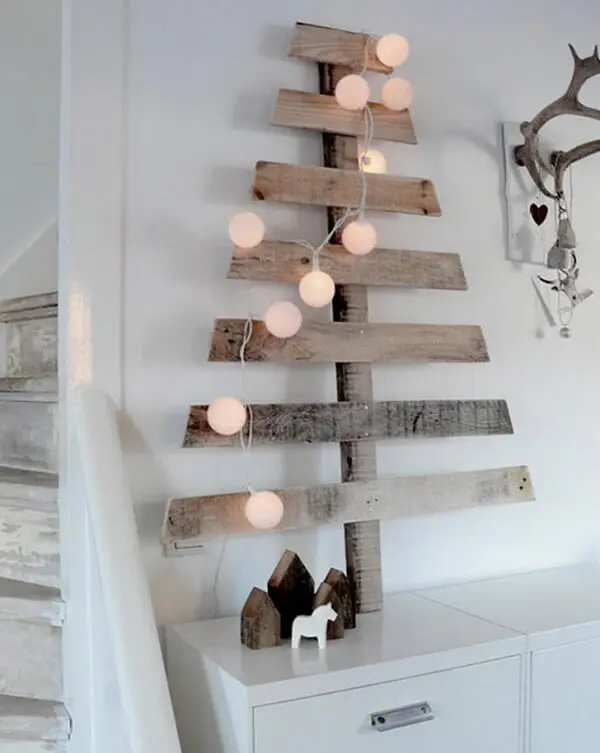 Árvore de Natal na parede feita com ripas de madeira