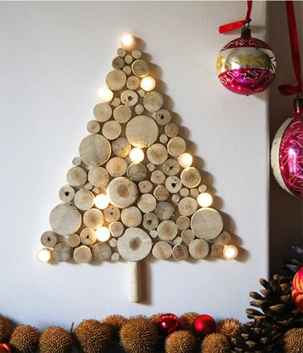 Árvore de Natal na parede feita com troncos cortados