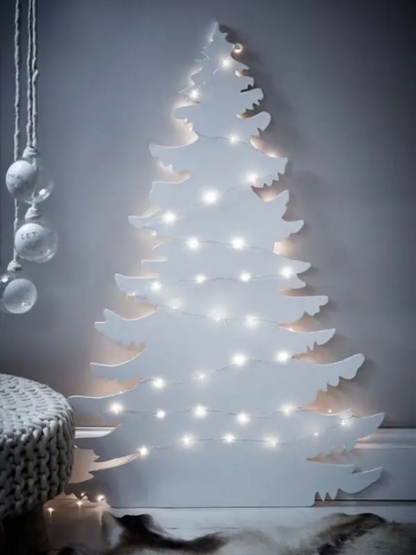 Árvore de Natal na parede feita com estrutura de madeira branca
