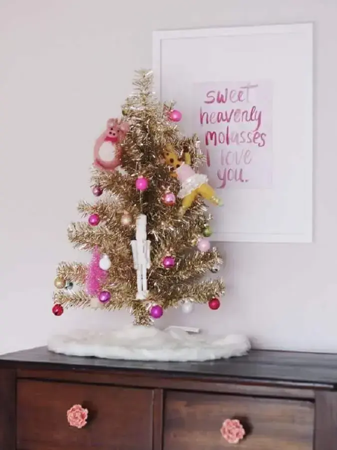 small golden Christmas tree decorated with pink ornaments CS Interior Photo